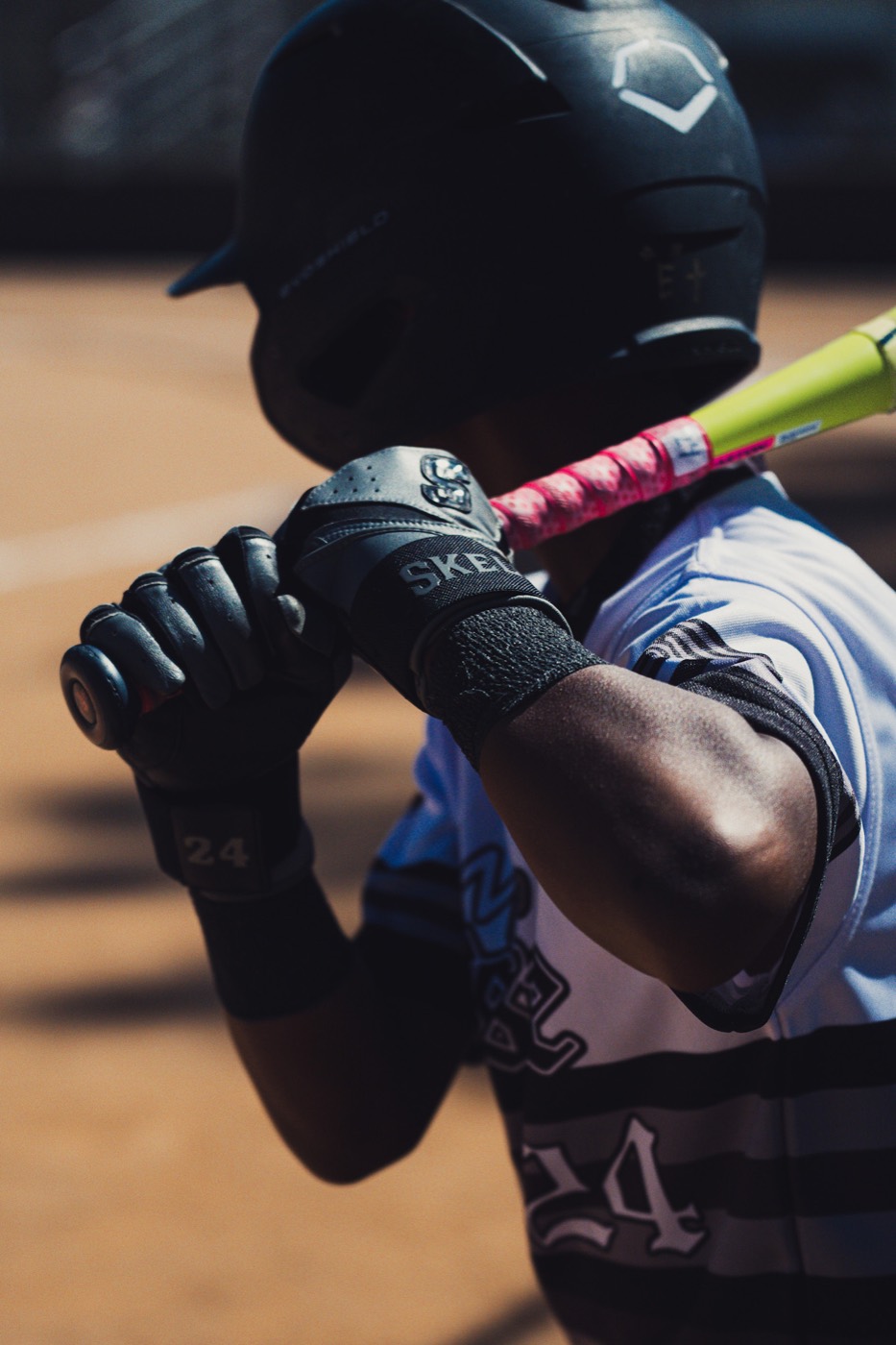 Close-up of a Skele10 batting glove gripping a bat